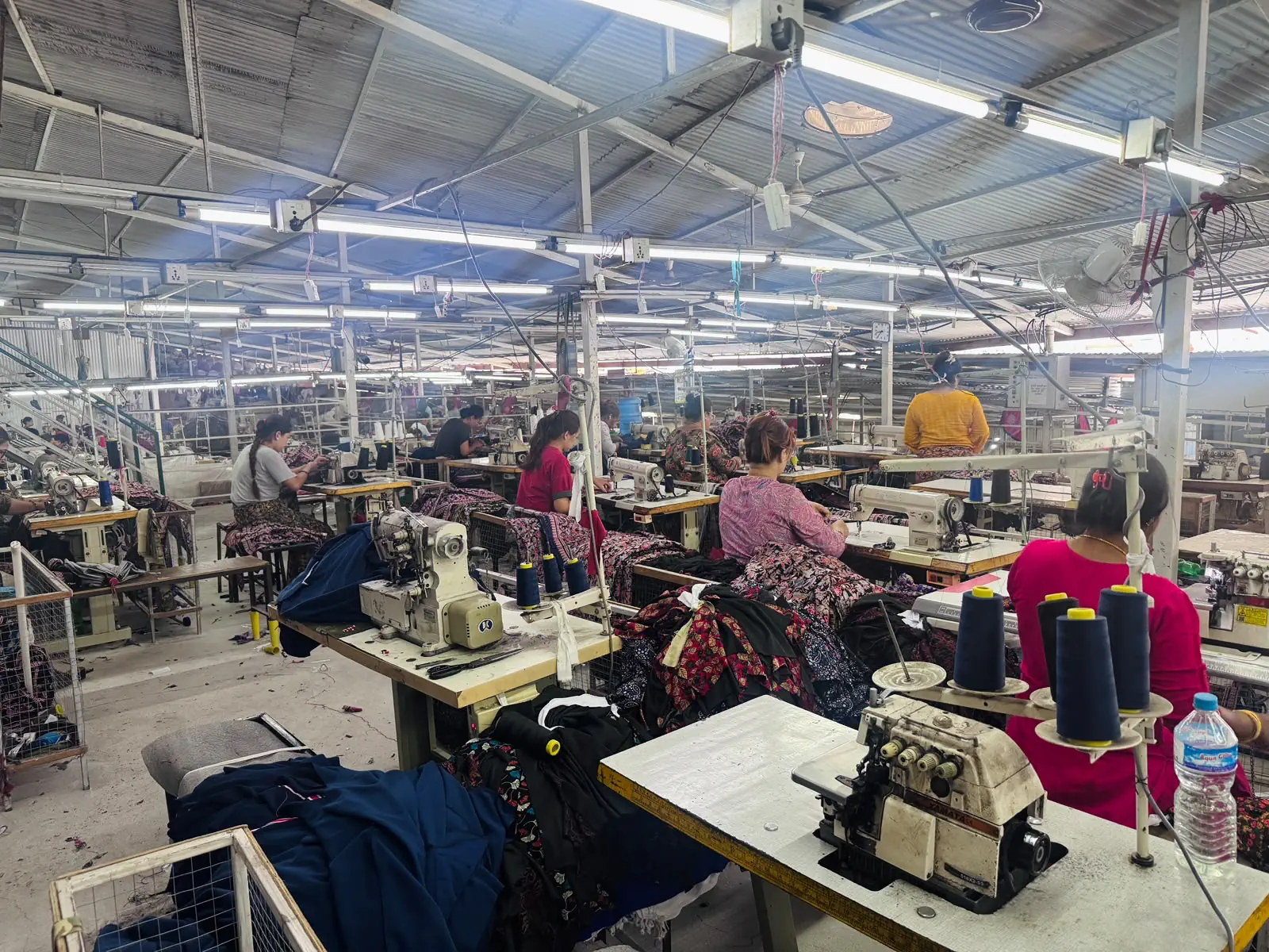 Garment production floor with sewing workstations and uniform fabric