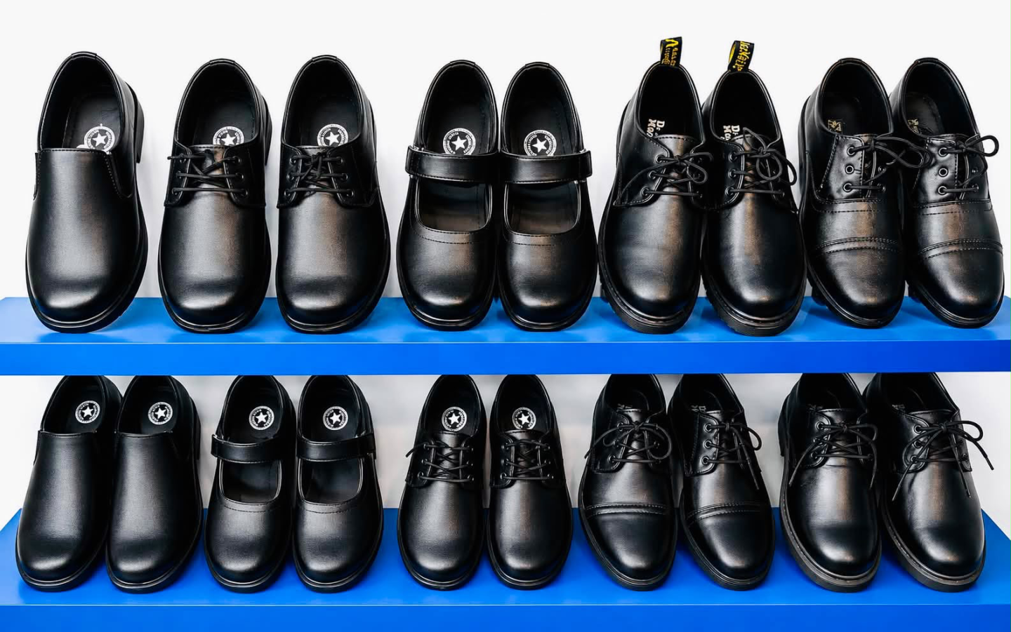 Formal black school shoes displayed on blue shelves