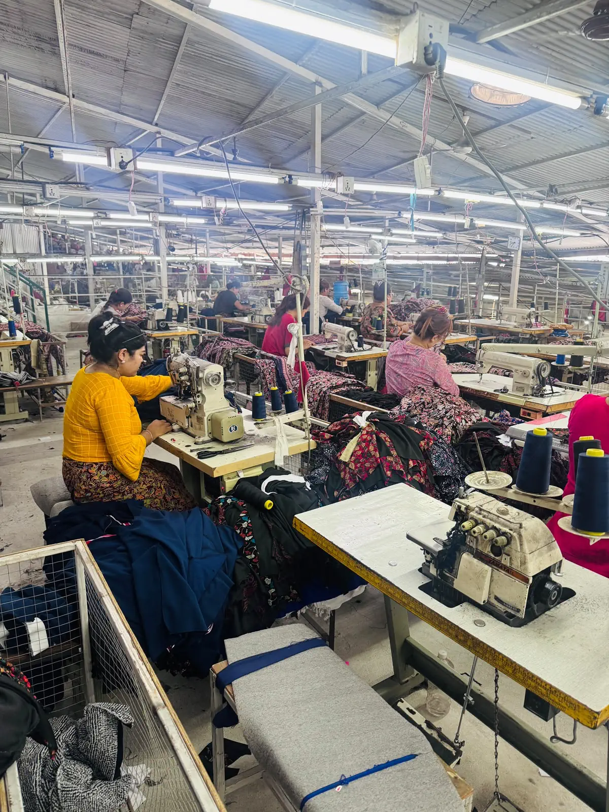 Tailoring production floor with sewing machines and garments in progress