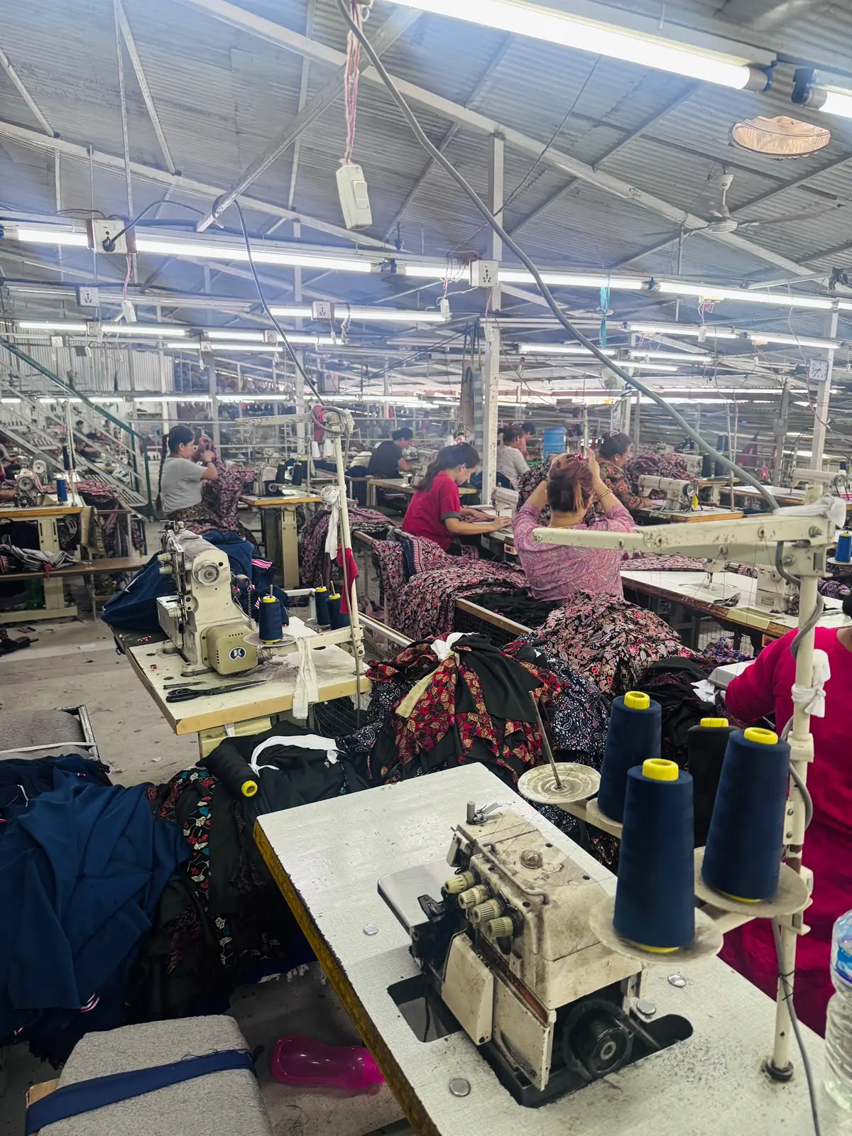 Tailoring workstations with sewing machines and uniform fabric